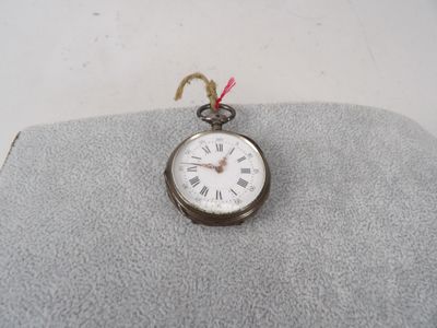 a silver pocket watch with roman numerals on it