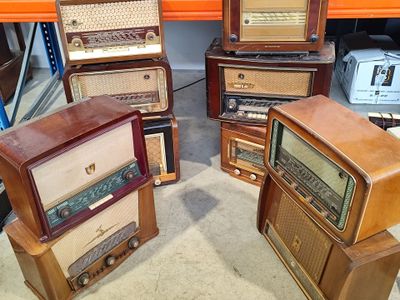 several old radio ' s are stacked on top of each other in a room