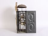 a small metal clock with a bird on top of it