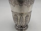 an antique silver cup with a decorative design on the rim