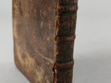 a close up of an old book on a white surface