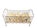 a metal basket with yellow and white plaid pillows in it