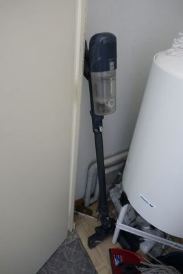 an image of a vacuum in the corner of a room
