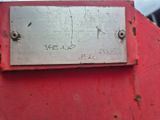 un gros plan d'une plaque métallique apposée sur un panneau « Stop » rouge