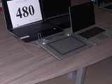 deux ordinateurs portables posés sur une table dans une pièce équipée de chaises orange