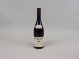 a bottle of red wine sitting on top of a white table