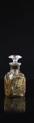 a glass bottle with a design on it on a black surface