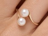 the pearl ring is on the finger of a woman ' s hand