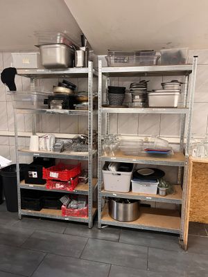 many pots and pans on the shelves in the kitchen