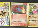 trois cartes pokemon posées les unes sur les autres sur une table