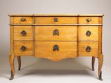 une commode ancienne avec des poignées et des boutons en laiton