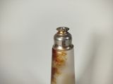 a silver pepper shaker with a brown substance on it