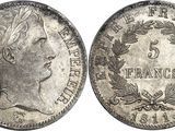 a silver coin with a woman ' s head and laurels on it