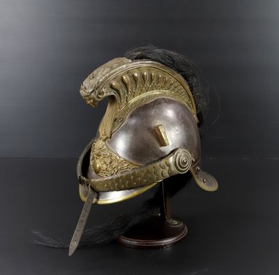 un casque ancien posé sur un socle, sur fond noir