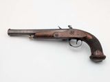 an old gun with a wooden handle on a white surface