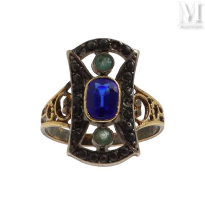 an image of a ring with a blue stone surrounded by green stones