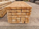 a lot of lumber stacked on the ground in the yard