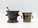 two antique brass mortars with handles and handles on a white background