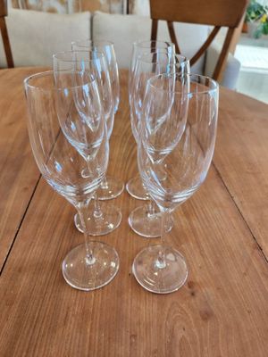 four empty wine glasses sitting on top of a wooden table