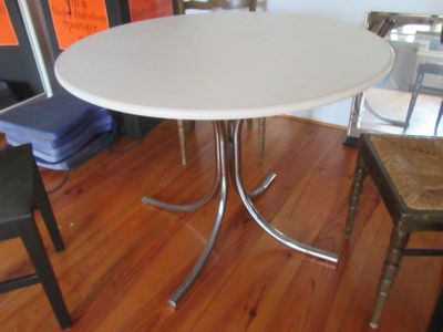 a white table and chairs in a room with wood flooring