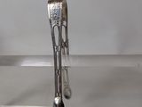 a silver spoon and spoon rest on a glass table