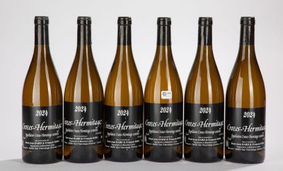 six bouteilles de vin sont alignées sur une surface blanche