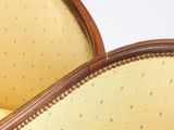 a close up of the back of a chair with a yellow upholstered seat
