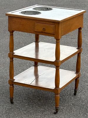 une petite table en bois avec un plateau en verre, posée dans la rue