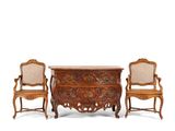 two chairs and a chest of drawers with carvings on the top