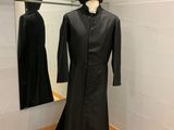 un mannequin vêtu d'une robe noire dans une pièce avec un miroir