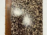 un gros plan d'un livre posé sur une table, avec un bout de papier à côté