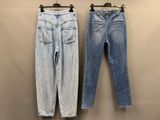 deux paires de jeans suspendues à un cintre contre un mur