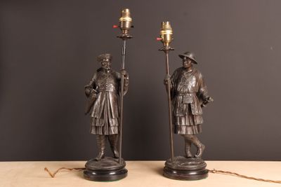 pair of antique bronze figures of a man and a woman holding torches