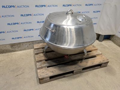 a large metal pot sitting on a pallet in front of a wall