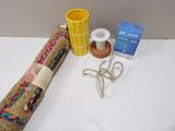 a roll of fabric, a cup, and a pair of scissors on a table