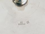 a silver plate with a silver lid and a silver handle