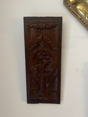 a wooden plaque on the wall next to a mirror