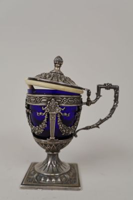 an antique silver and blue glass teapot on a stand