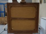 a wooden easer with a painting on it in the middle of a room