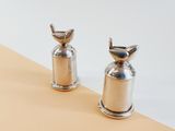 two silver pepper grinds sitting on top of a table