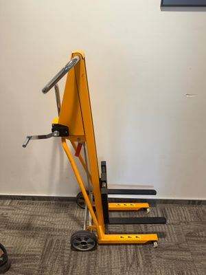 a small yellow crane sitting in a room next to a wall