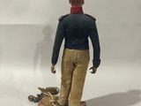 a figurine of a man with a dog on a leash