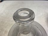 a glass bottle with a metal stopper on a table