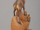 a statue of a goat on a rock on a table
