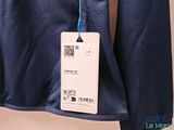 the back of a blue jacket hanging on a hanger on a wall