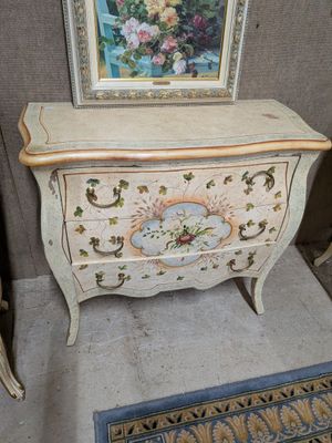 une photo d'un tableau posé sur une commode dans une pièce