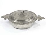 an antique silverplated casserole with a lid on a white background