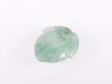 a green jade stone on a white surface