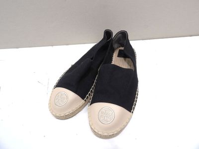 une paire d'espadrilles noires et blanches posées sur une surface blanche