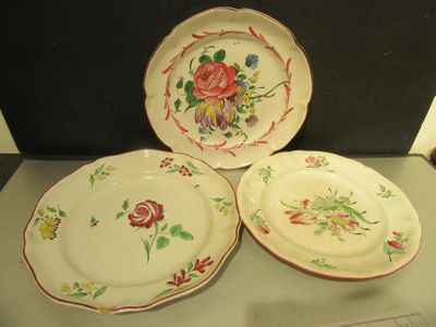 trois assiettes à motifs floraux posées sur une table